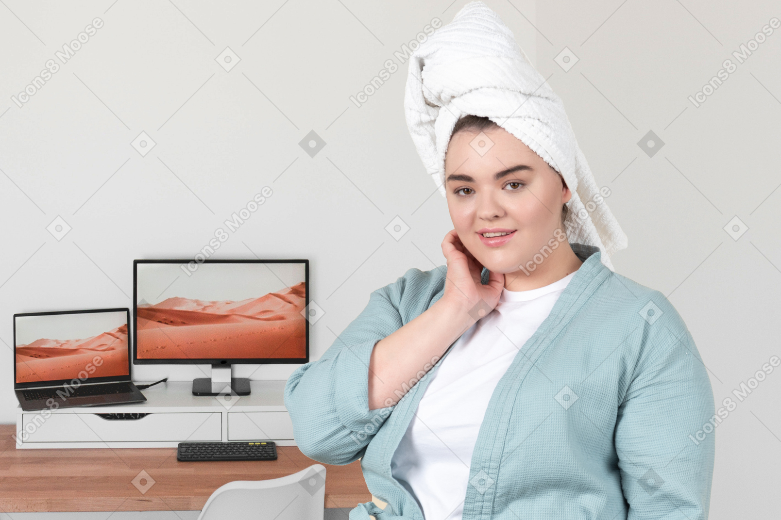 A woman with a towel on her head standing in front of a computer