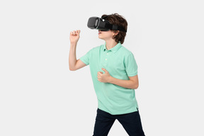 Garoto com fone de ouvido de realidade virtual segurando algo