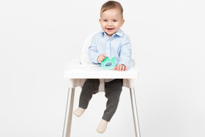 笑的男婴坐在高脚椅