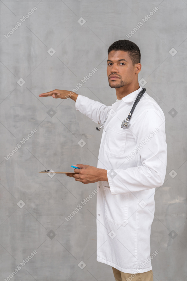 Médico com estetoscópio e prancheta mostrando a altura de algo