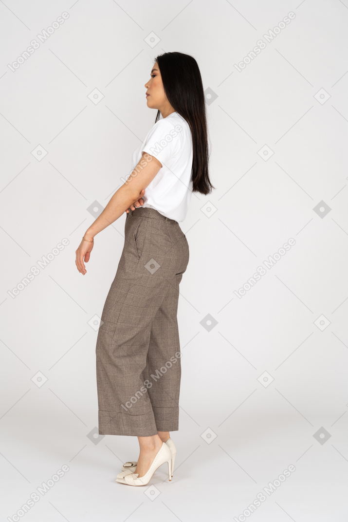 Side view of a displeased young lady in breeches and t-shirt