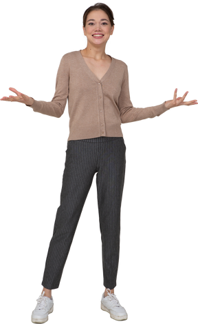 Front view of a delighted lady in beige pullover raising her hands