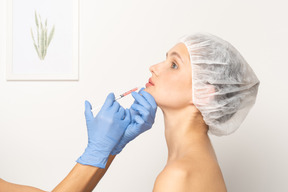 Vista lateral de uma mulher recebendo injeção de botox