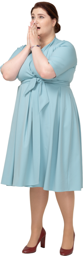 Вид спереди впечатленной женщины в синем платье