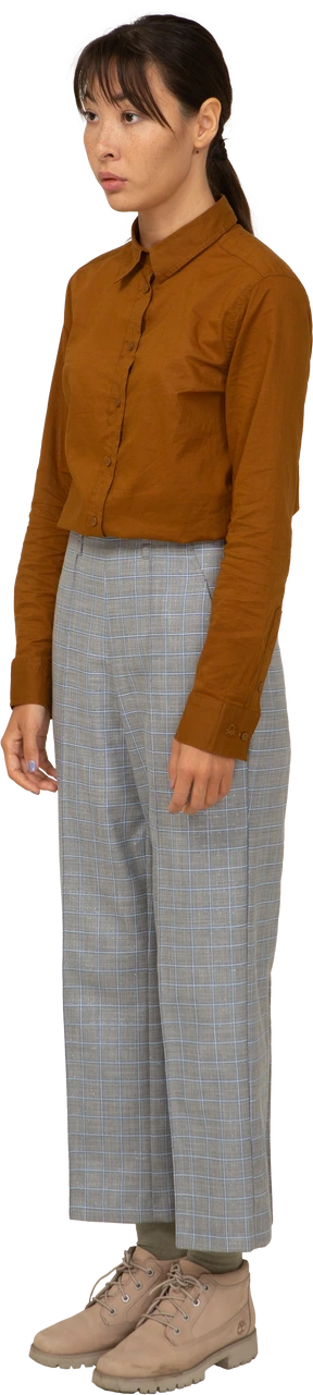 Three-quarter view of a young asian female in breeches and blouse standing still