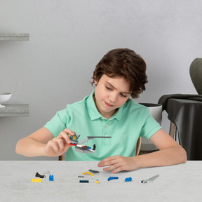 A young boy sitting at a table playing with legos