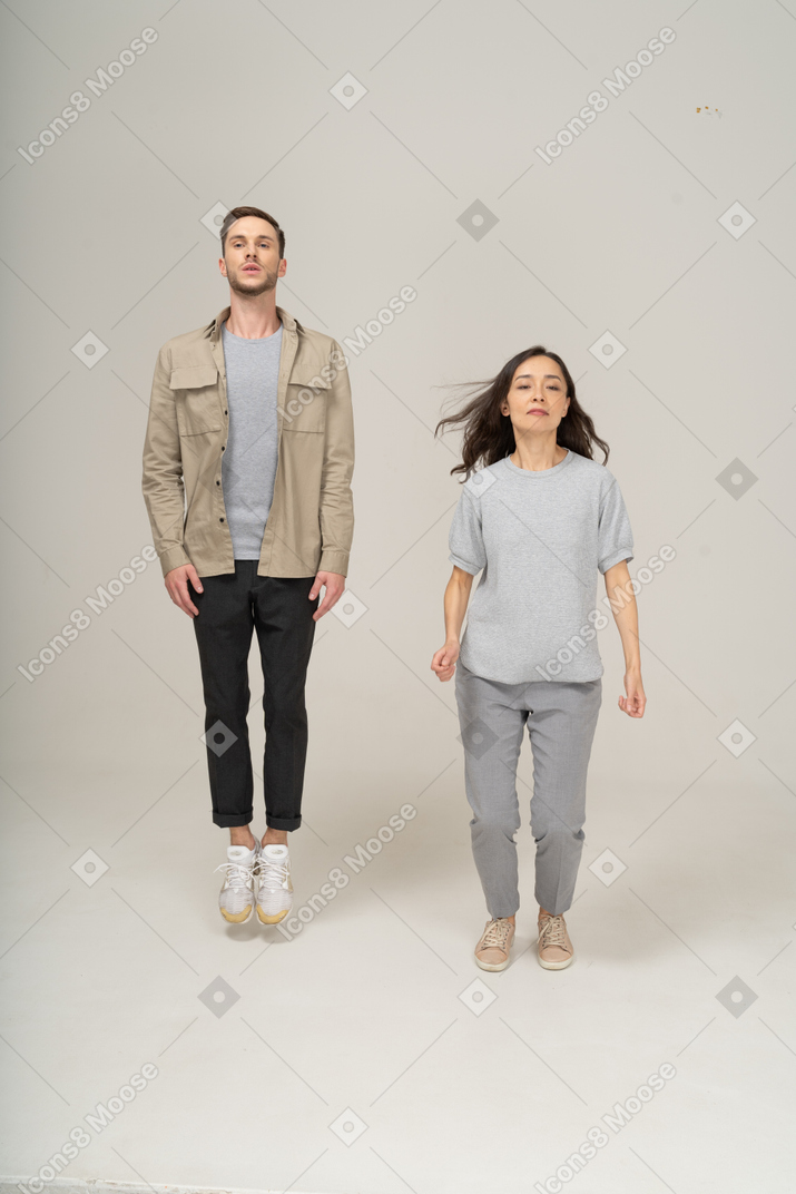 Young man jumping with woman landing