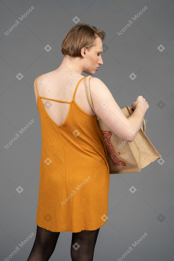 Back view of a queer person looking inside the bag