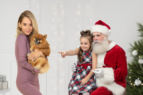 Little girl sitting on santa's knees wants to get a dog