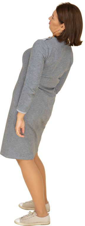Vista lateral de uma mulher em um vestido cinza posando