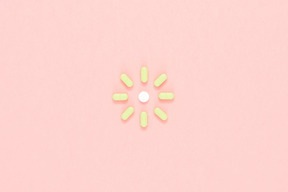 Green pills arranged in a shape of sun