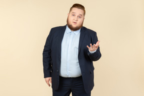 Young overweight man in suit looking bothered with something