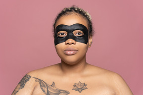 Femme utilisant un masque pour les yeux noirs