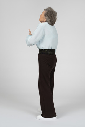 Back view of an old woman sneezing
