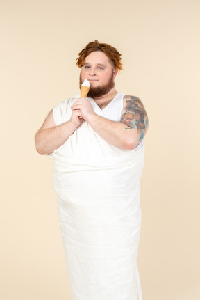 Hombre grande vestido como un cupido comiendo helado