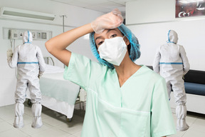 A woman wearing a surgical mask in a hospital
