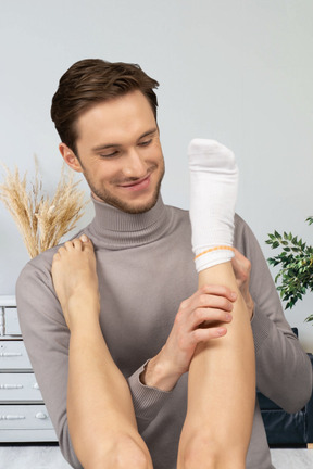 A man taking off a sock from a female leg