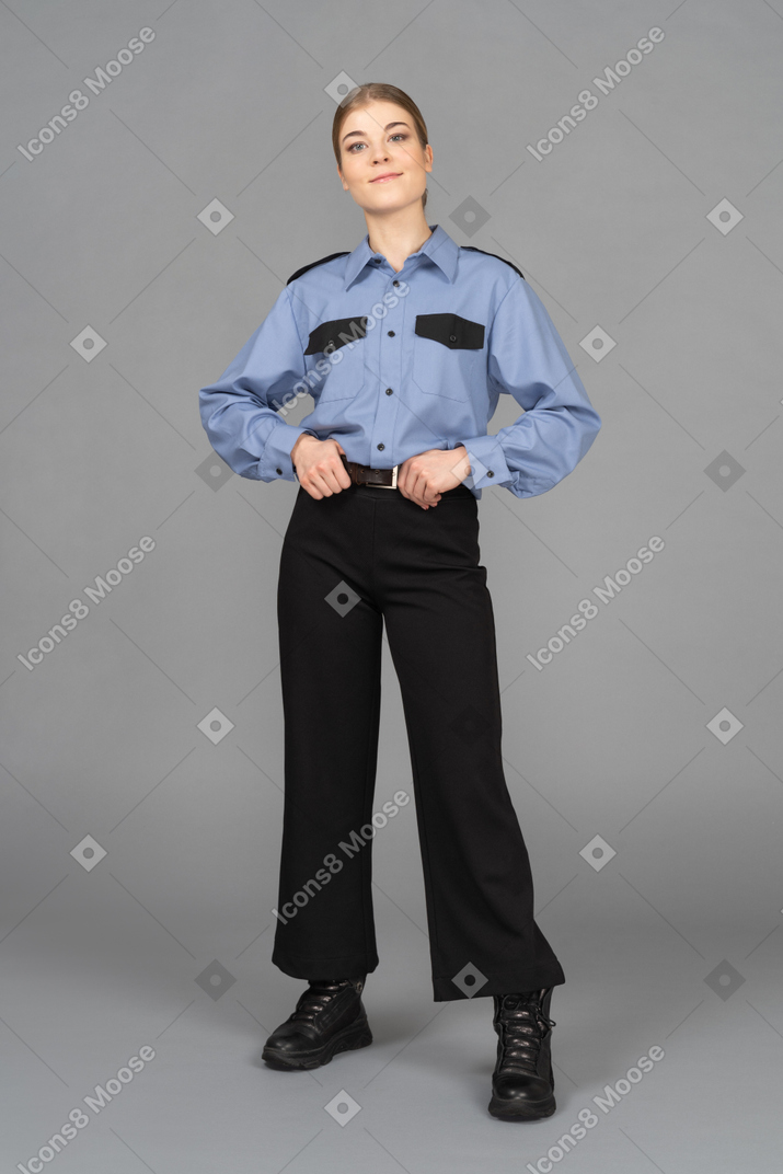 Female security guard standing with her hands on the belt