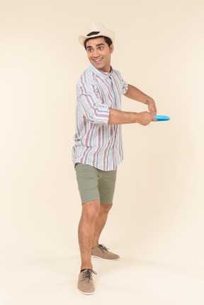 Young caucasian guy throwing frisbee