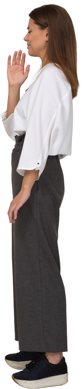 Three-quarter view of a displeased young lady in office clothing waving hand