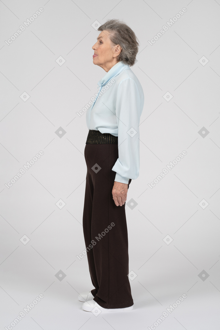 Vista laterale di una donna anziana che si lecca le labbra