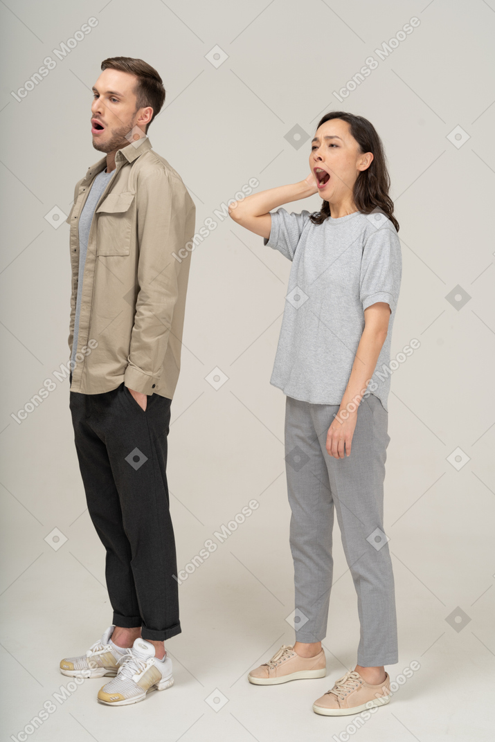 Vista de três quartos do jovem casal bocejando