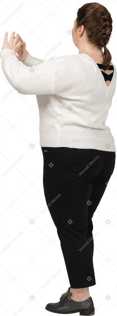 Mujer regordeta en suéter blanco que muestra la figura del corazón con los dedos