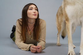 Pleine longueur d'une maîtresse couchée et son chien de départ