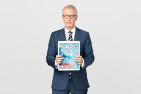 Elegant middle-aged business man showing his tablet