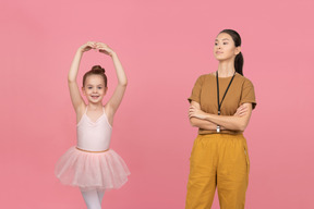Professora de dança olhando orgulhosamente para seu pequeno aprendiz