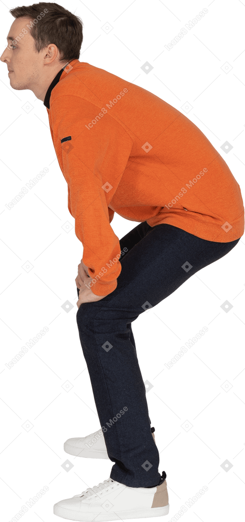 Junger mann im orange sweatshirt posiert