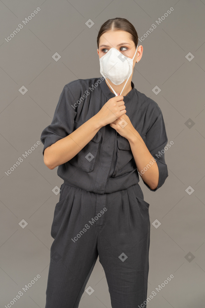 人工呼吸器を着用した灰色のカバーオールの女性