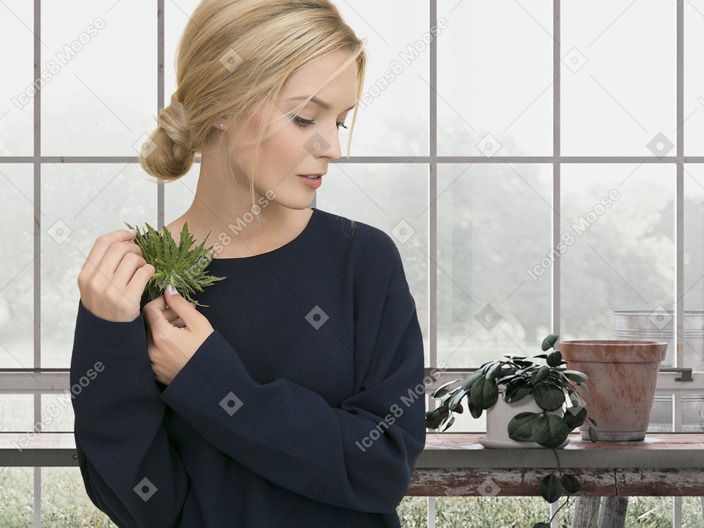 A woman holding a plant near her face