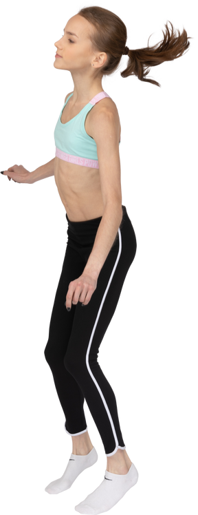 Vista lateral de uma adolescente dançando roupas esportivas