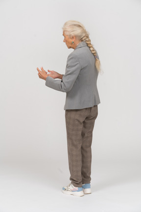 Side view of an old lady in suit explaining something