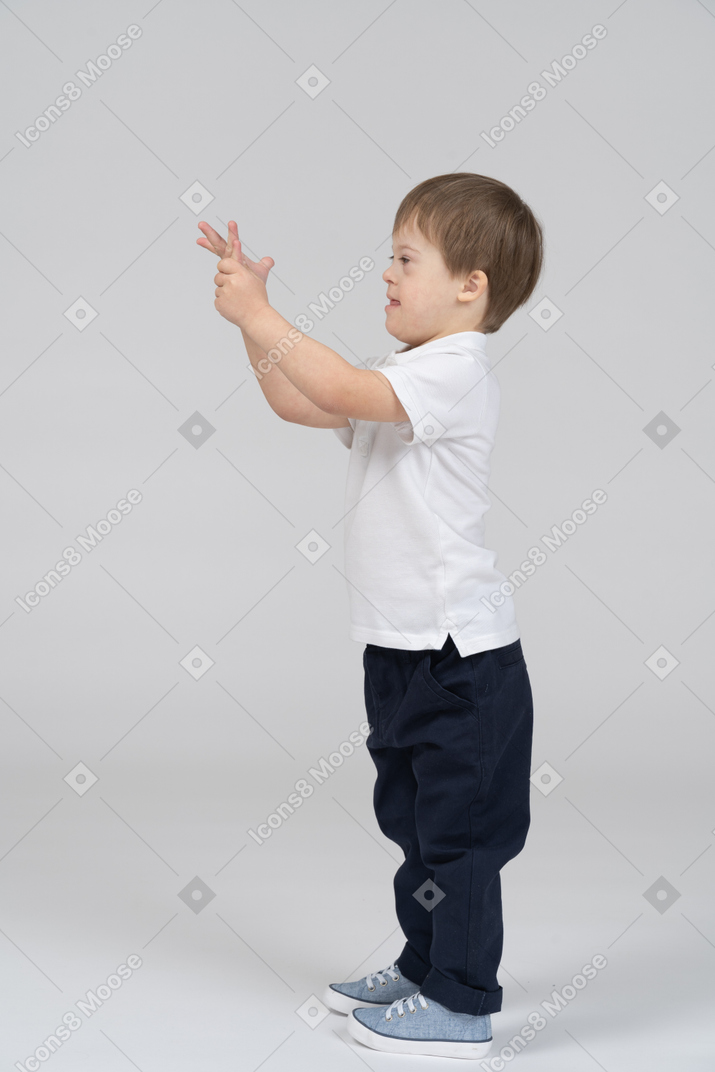 Side view of young boy looking at his hand