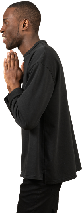 Vista lateral de um homem com mãos rezando