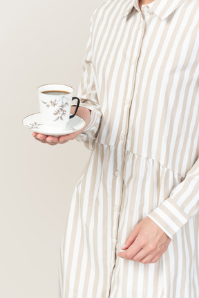 Mão feminina segurando xícara de chá