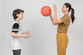 Pe female teacher and her pupil practicing serves' techniques