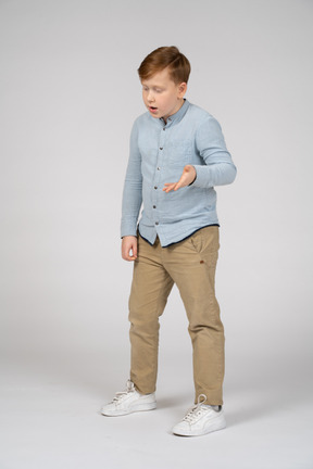 Young boy in blue shirt and khaki pants explaining something