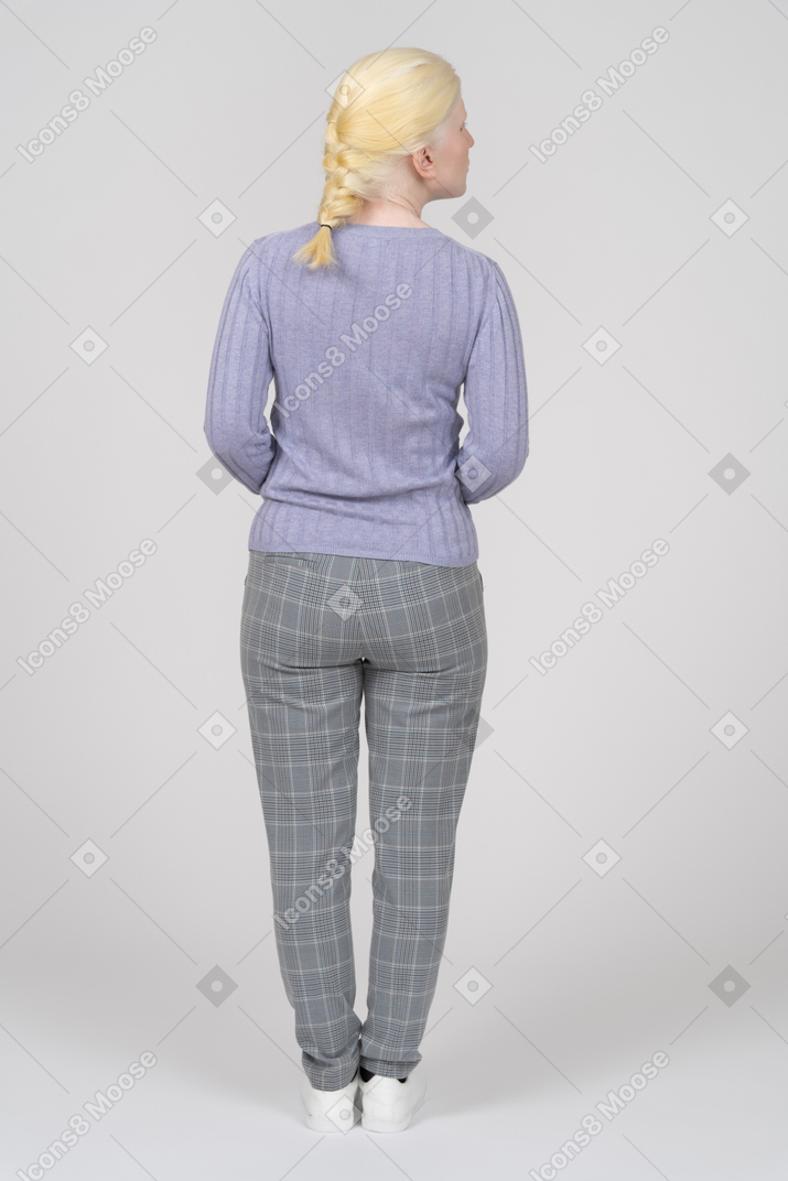 Back view of a young woman in casual clothes looking to the right