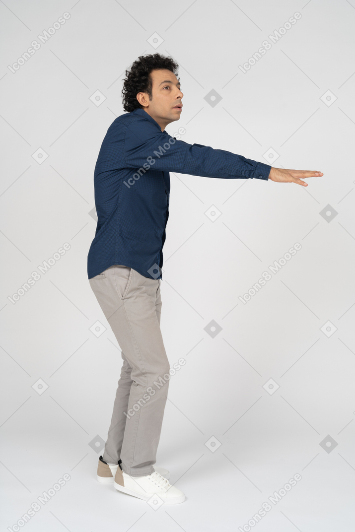 Vista laterale di un uomo in abiti casual in piedi con le braccia tese