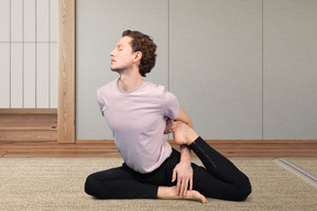 A man sitting on the floor in a yoga pose