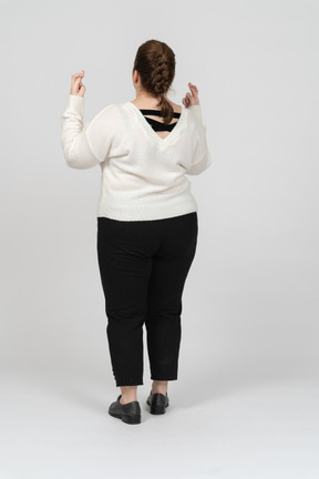 Plus size woman in casual clothes crossing fingers