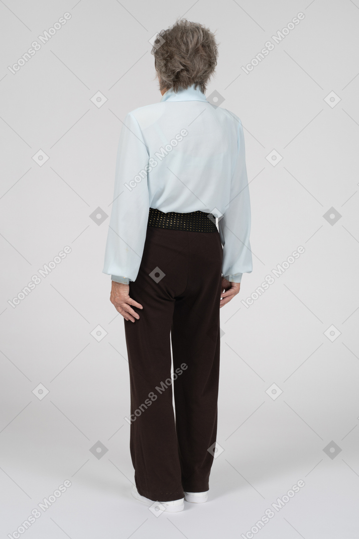 Vista posteriore di tre quarti di una donna anziana in abiti formali