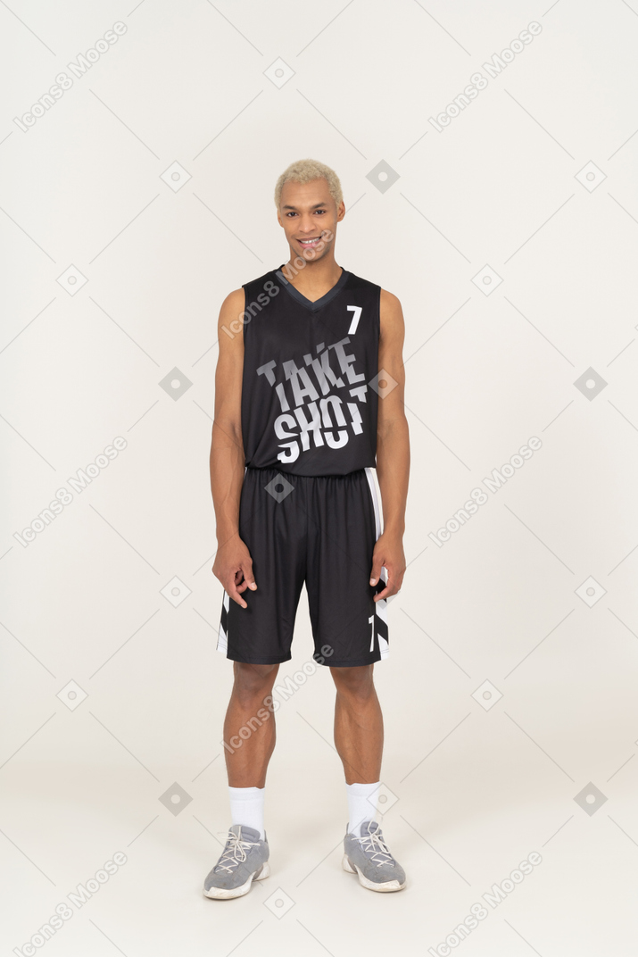一个微笑的年轻男篮球运动员站着不动的前视图