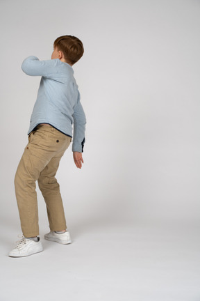 Back view of a young boy in blue shirt