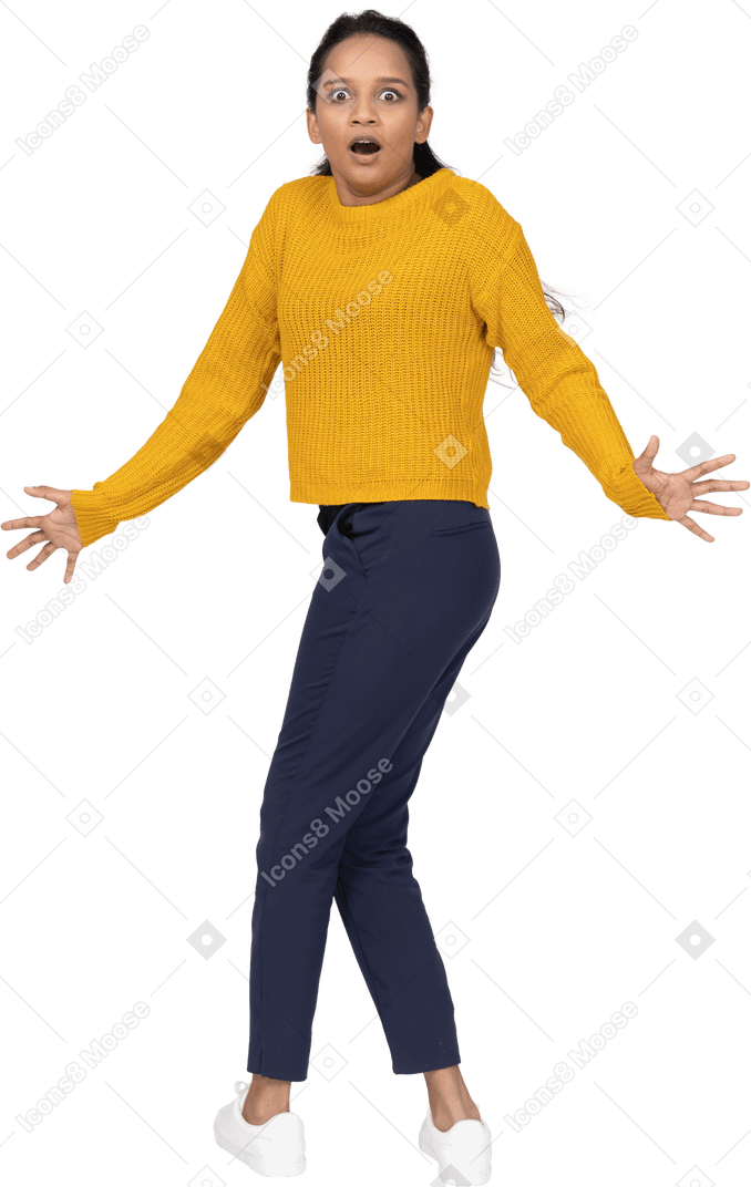 Emotional girl in casual clothes standing with outstretched arms and looking at camera