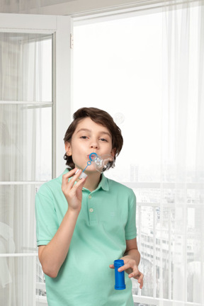 Cheerful boy blowing bubbles