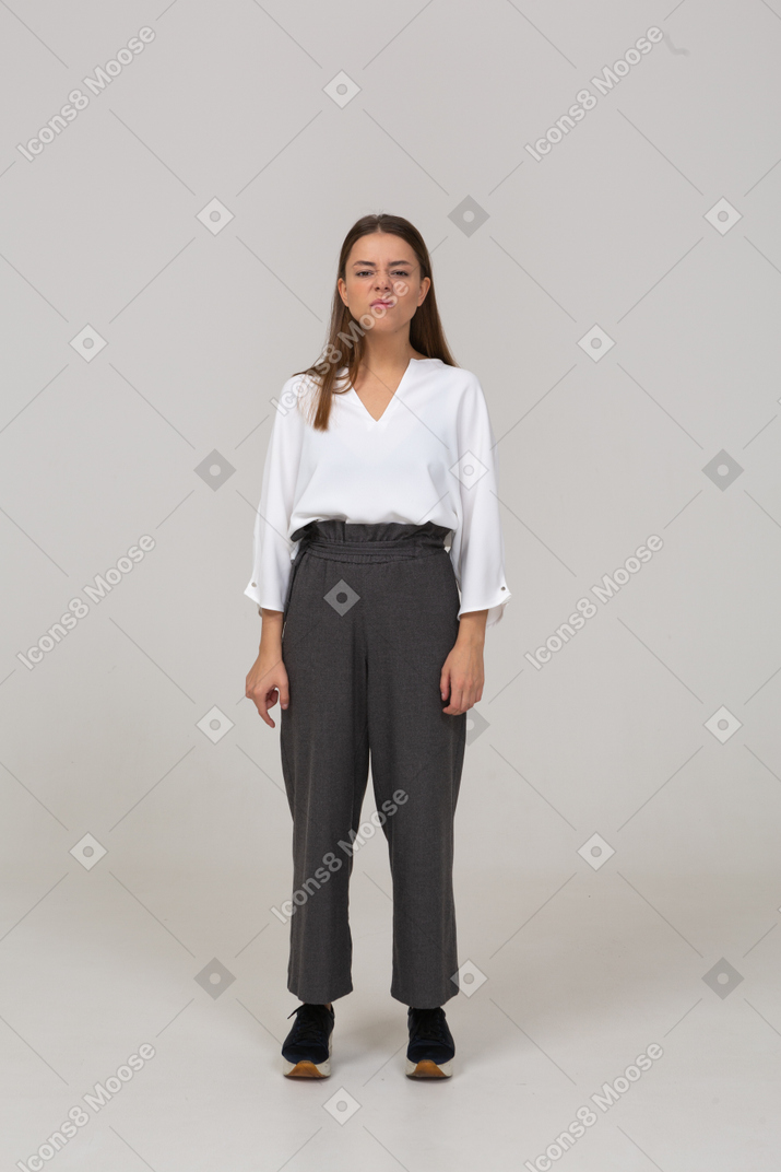 Vista frontal de uma jovem descontente com roupas de escritório olhando para o lado
